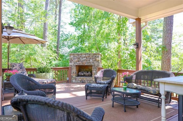 view of terrace with an outdoor living space with a fireplace and a wooden deck