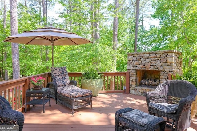 wooden terrace featuring an outdoor stone fireplace