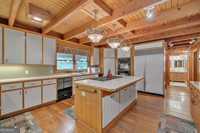 kitchen featuring hanging light fixtures, white cabinetry, a center island, and black appliances