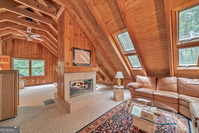 unfurnished living room with light carpet, a fireplace, wood walls, and vaulted ceiling with skylight