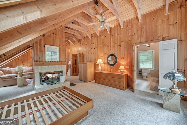 carpeted living room with beam ceiling, a tile fireplace, ceiling fan, wooden ceiling, and wood walls