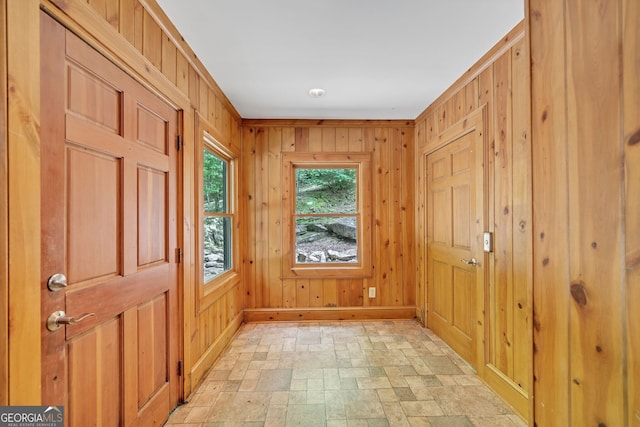 entryway with wooden walls and ornamental molding