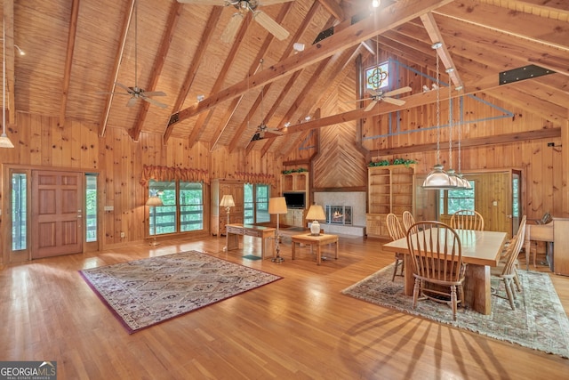 unfurnished dining area with beamed ceiling, wooden walls, high vaulted ceiling, and wooden ceiling