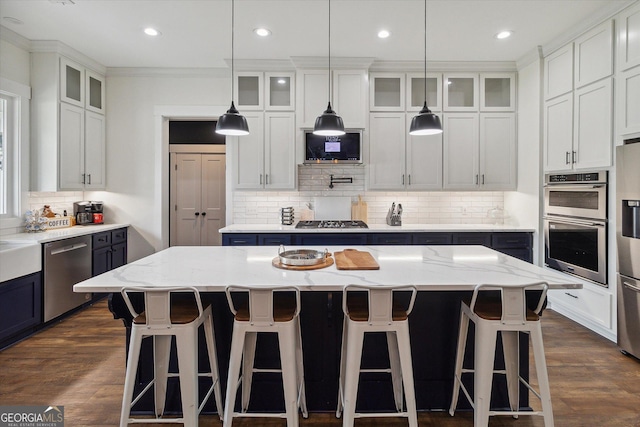 2879 Lakeview Rd, Statesboro, GA 30461 - kitchen with appliances with stainless steel finishes, tasteful backsplash, a kitchen island, blue cabinets, and a breakfast bar