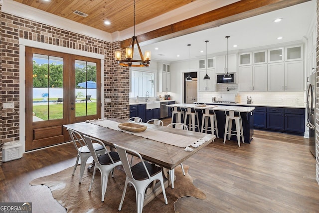 2879 Lakeview Rd, Statesboro, GA 30461 - dining space with french doors, crown molding, dark wood finished floors, a chandelier, and wood ceiling