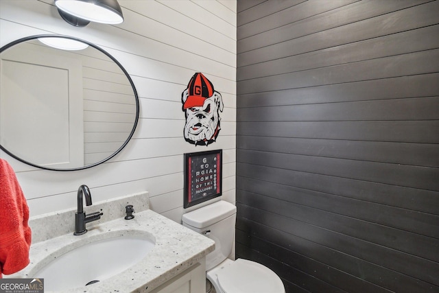 2879 Lakeview Rd, Statesboro, GA 30461 - bathroom featuring wooden walls, toilet, and vanity