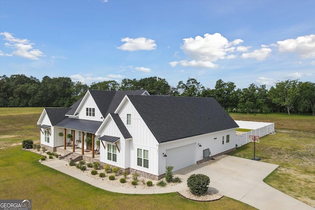 2879 Lakeview Rd, Statesboro, GA 30461 - view of front of house featuring board and batten siding, a front lawn, concrete driveway, an attached garage, and a shingled roof