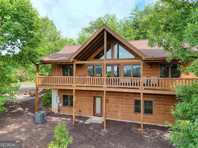 back of property featuring central AC unit, roof with shingles, and a wooden deck