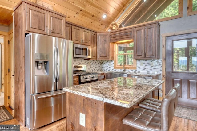 kitchen featuring stainless steel appliances, backsplash, wood ceiling, vaulted ceiling, and light stone countertops