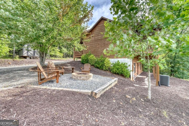 view of yard featuring a shed, a fire pit, and an outbuilding