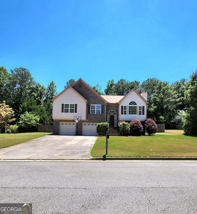 raised ranch with an attached garage, brick siding, concrete driveway, and a chimney