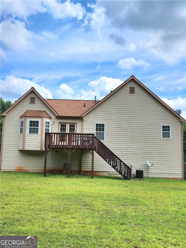 rear view of house with a wooden deck, central AC, and a lawn