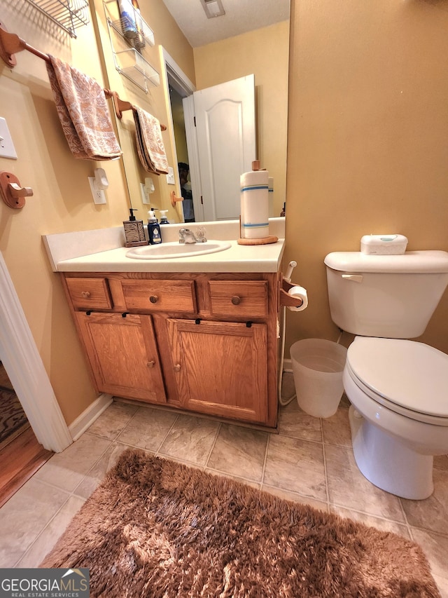 bathroom with vanity, toilet, and tile patterned floors