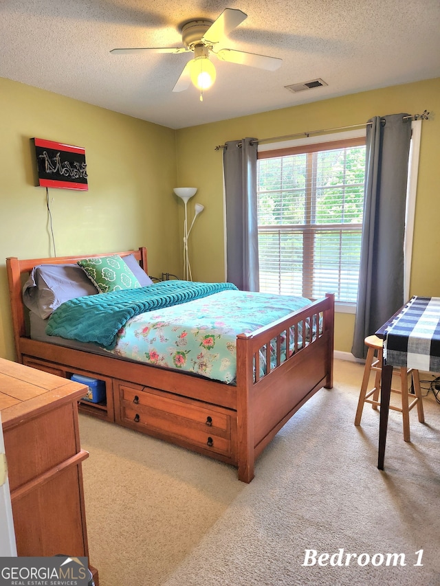 carpeted bedroom featuring a textured ceiling and ceiling fan