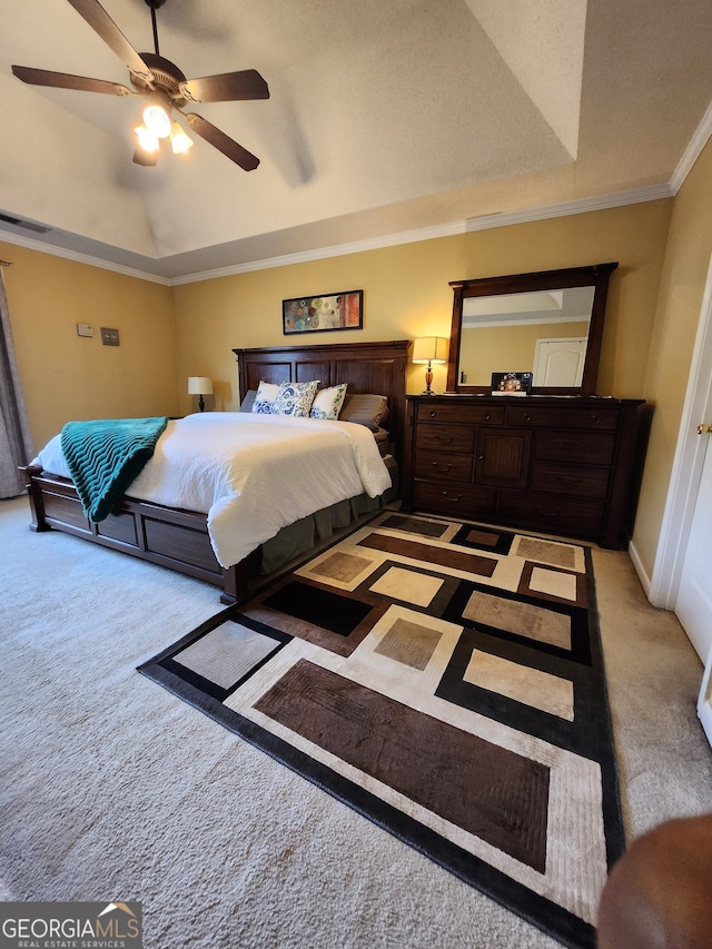 carpeted bedroom featuring ceiling fan, crown molding, and a raised ceiling