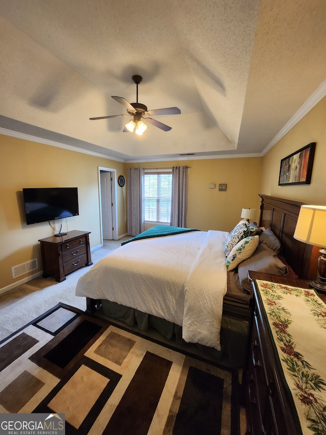 bedroom with ceiling fan, crown molding, a textured ceiling, and light colored carpet