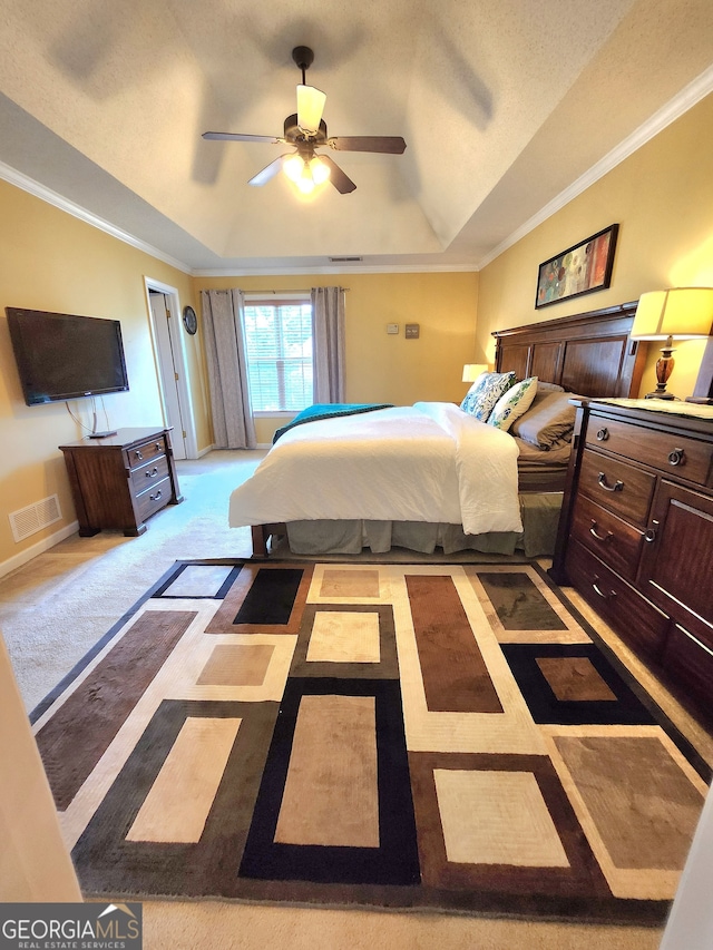 bedroom with crown molding, a raised ceiling, light colored carpet, and ceiling fan