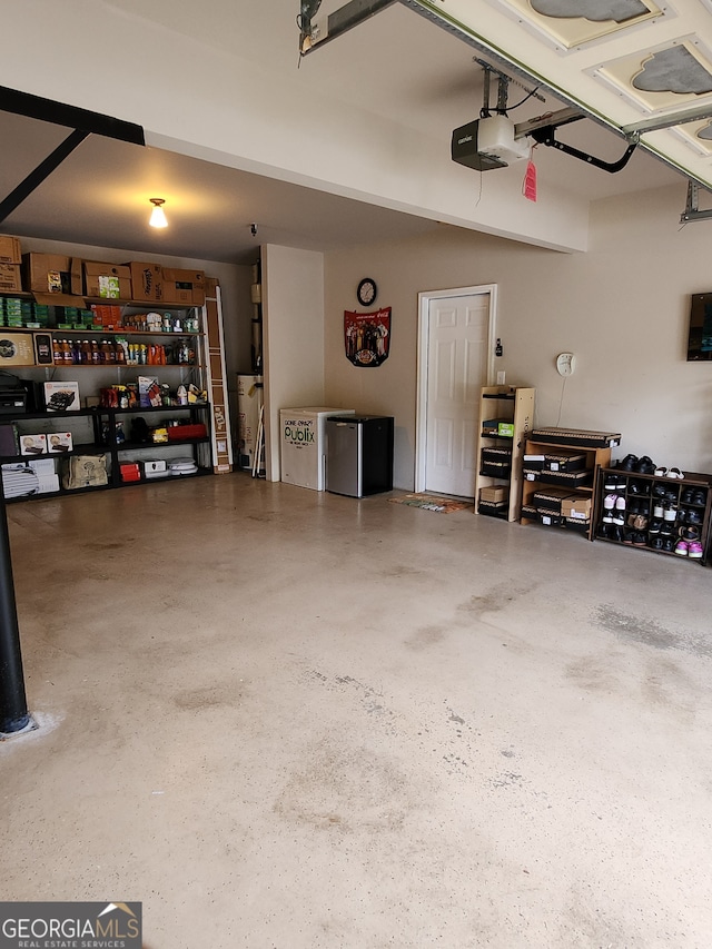 garage featuring a garage door opener and stainless steel refrigerator