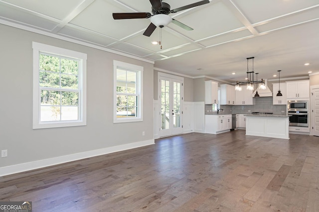 kitchen featuring french doors, stainless steel appliances, a kitchen island, pendant lighting, and white cabinets