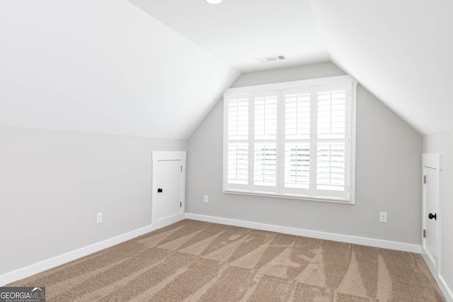 bonus room with carpet, a healthy amount of sunlight, and vaulted ceiling