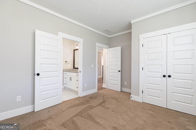 unfurnished bedroom with connected bathroom, light carpet, a closet, and ornamental molding