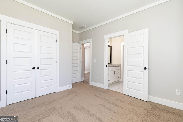 unfurnished bedroom featuring ornamental molding, light carpet, connected bathroom, and a closet