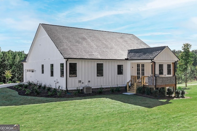 view of front of property featuring a front lawn, french doors, and central AC unit