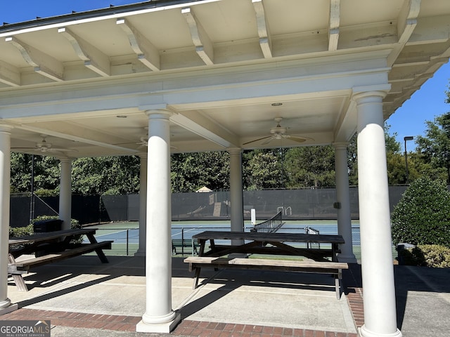 view of patio featuring ceiling fan and tennis court