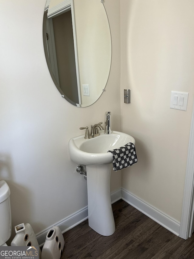 bathroom with toilet and wood-type flooring