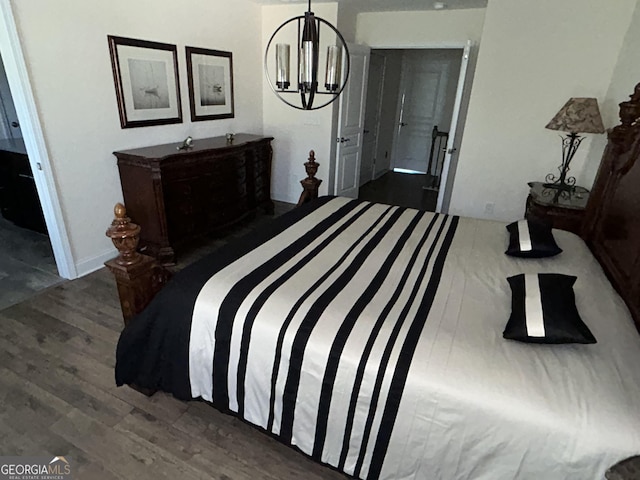 bedroom featuring dark hardwood / wood-style flooring and an inviting chandelier