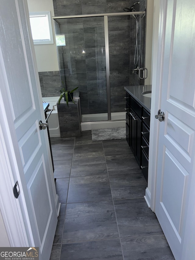 bathroom with tile patterned flooring, an enclosed shower, and vanity