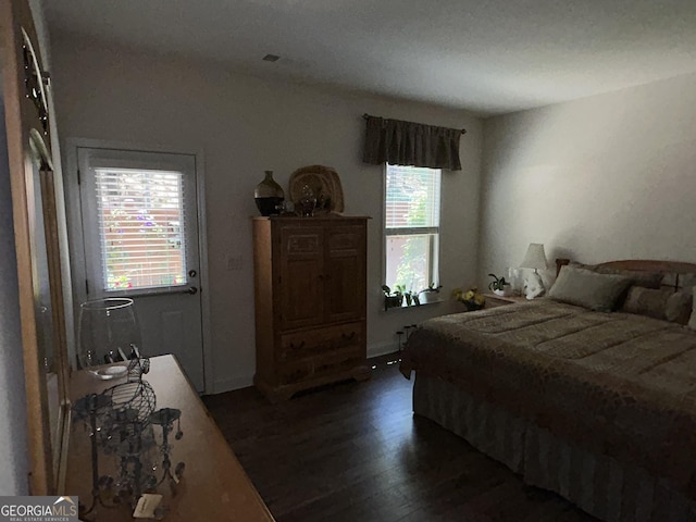 bedroom featuring dark hardwood / wood-style floors and multiple windows