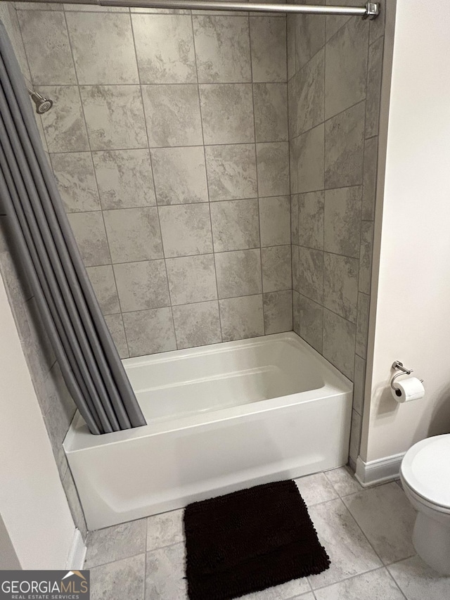 bathroom with toilet, shower / bath combo, and tile patterned flooring