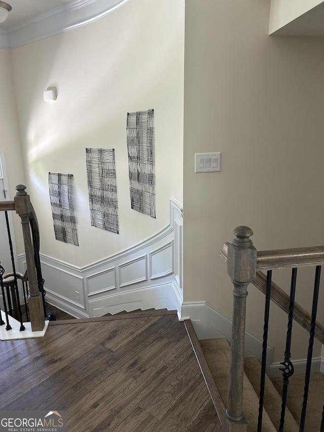 stairway featuring ornamental molding and hardwood / wood-style floors