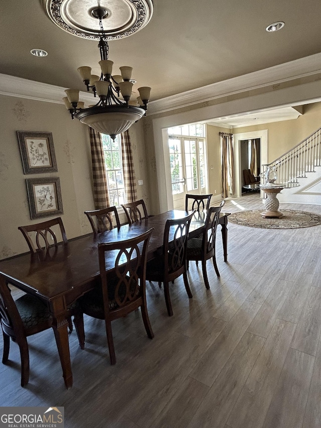 dining area with a wealth of natural light, hardwood / wood-style floors, ornamental molding, and a chandelier