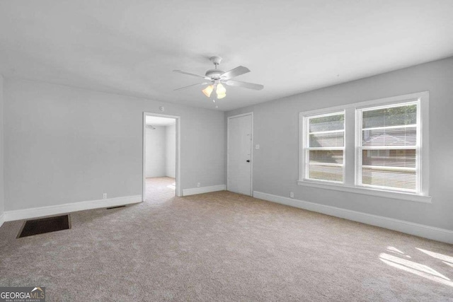 empty room featuring light carpet and ceiling fan