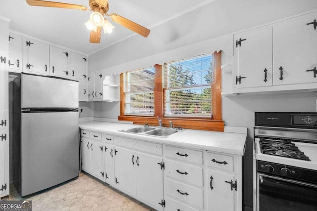 kitchen with stainless steel refrigerator, white cabinets, ceiling fan, white range with gas stovetop, and sink