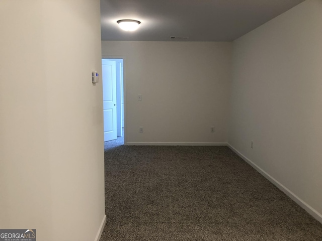 unfurnished room with dark colored carpet