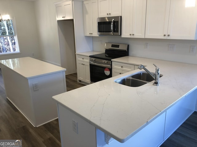 kitchen featuring white cabinets, a kitchen island with sink, sink, and appliances with stainless steel finishes