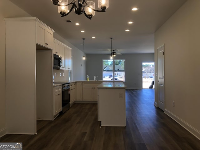 kitchen with white cabinetry, dark wood-type flooring, kitchen peninsula, ceiling fan with notable chandelier, and appliances with stainless steel finishes