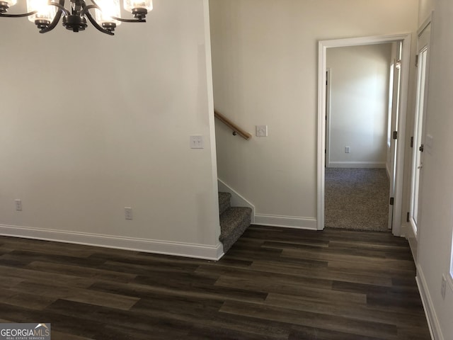 staircase featuring hardwood / wood-style flooring and a chandelier