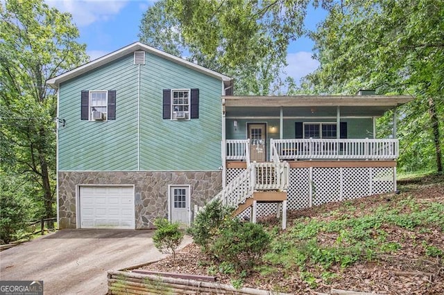 split level home with a garage, covered porch, and cooling unit