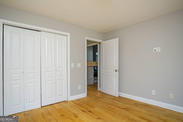 unfurnished bedroom featuring light hardwood / wood-style flooring and a closet