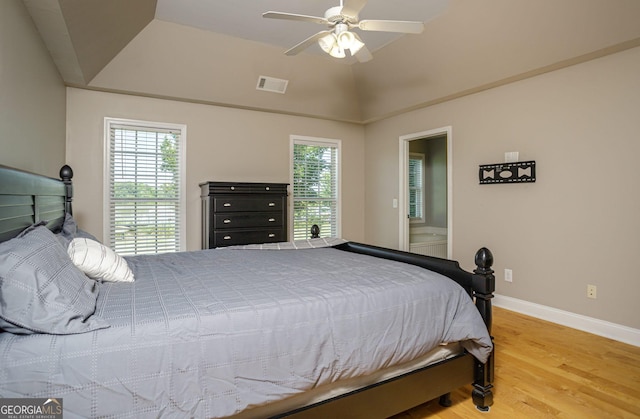 bedroom with connected bathroom, hardwood / wood-style flooring, ceiling fan, and lofted ceiling