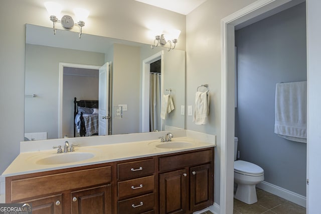 bathroom featuring tile patterned flooring, vanity, and toilet