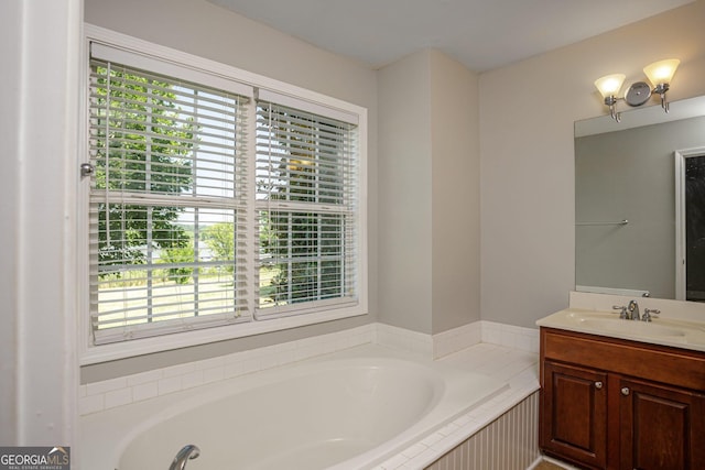 bathroom with vanity and tiled bath