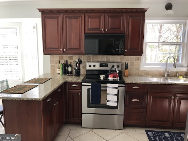 kitchen featuring tasteful backsplash, light stone countertops, sink, and electric range