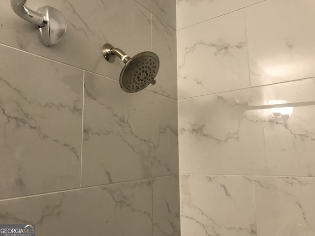 interior details featuring tiled shower