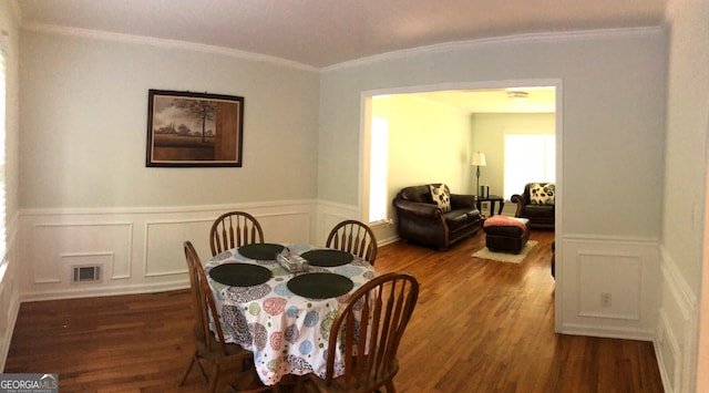 dining area with dark wood-type flooring and ornamental molding