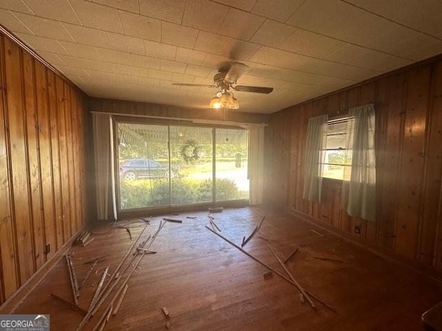 misc room with ceiling fan and wood walls